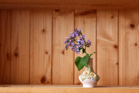 One vase with flowers at wooden background from side viewの写真素材