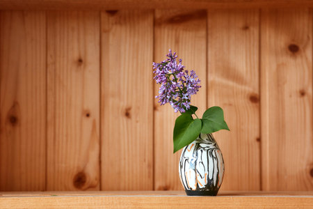 One vase with flowers at wooden background from side viewの写真素材