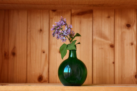 One vase with flowers at wooden background from side viewの写真素材