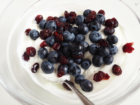Blueberries and cranberries in yogurtの写真素材