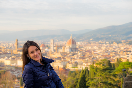 Beautiful girl impressed view the panorama of Florence in autumn sunset, Tuscany, Italyの写真素材