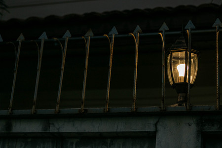 Lantern on the wall in dark balustrade