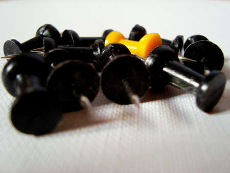 Black pushpins and the odd yellow oneの写真素材