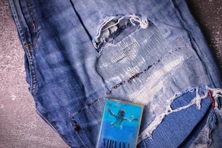 WASHINGTON, USA - September 30 2022 : Nirvana's cassette tape and Ripped jeans or Torn jeans. A symbol of the grunge or Seattle sound.のeditorial素材