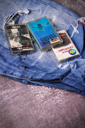 WASHINGTON, USA - September 30 2022 : Nirvana's cassette tape and Ripped jeans or Torn jeans. A symbol of the grunge or Seattle sound.のeditorial素材