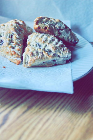 blueberry scones served in a white plate on a wooden table, pictured in modern tones.の写真素材