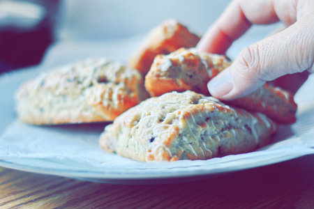 blueberry scones served in a white plate on a wooden table, pictured in modern tones.の写真素材