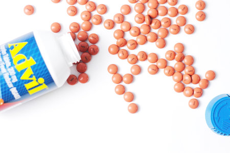 Washington, USA - October 02  2022 : Bottles of advil and pills spread on a white table. Fever, painkiller, popular American painkiller, ibuprofen.のeditorial素材