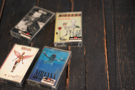 Bangkok, Thailand - January ,22 2022 : 90's cassette tapes of Nirvana Albums Incesticide, Nevermind, Bleach, From The Muddy Banks of The Wishkah on a black wooden floor.のeditorial素材