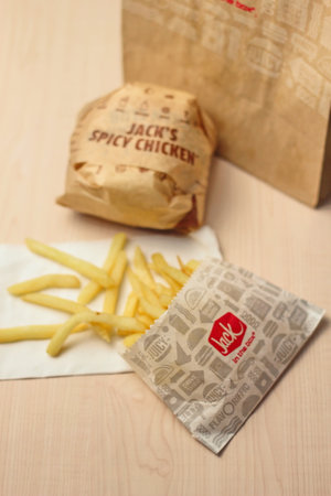 WASHINGTON, USA - January 10, 2023 : A home-style rance chiken club burger or Jack Spicy Chicken Burger served on a wooden table in a jack in the box restaurant in the USA.のeditorial素材