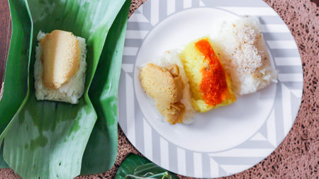 3 flavors Thai desserts, sticky rice, custard topped with dried fish and yellow sticky rice, wrapped in banana leaves in thailand.の写真素材