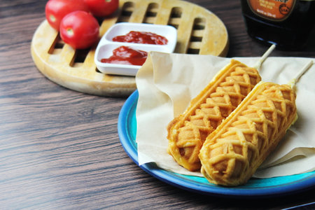 waffle sticks, Corn dogs,Hot Dog Waffles on a Stick & Ketchup on a wooden table