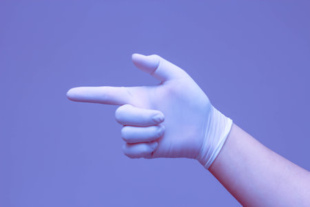 Hands wearing rubber gloves symbolize "correct" with a blue background.の写真素材