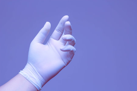Hands wearing rubber gloves symbolize "tired" with a blue background.の写真素材