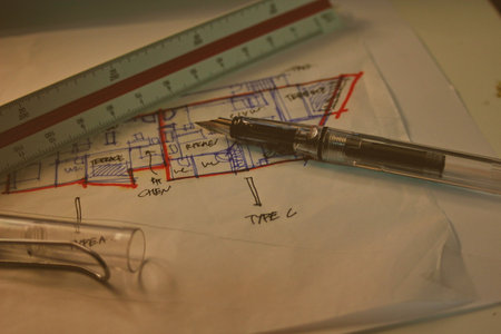 Pencil and ruler on a sheet of paper with an architectural plan
