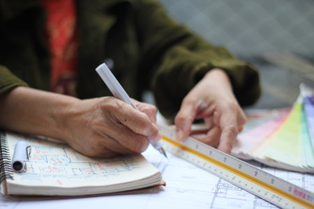 Hands of Asian female engineers are working on construction drawings on site.の写真素材