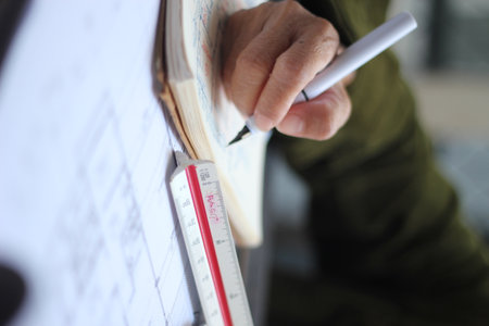 Hands of Asian female engineers are working on construction drawings on site.の写真素材