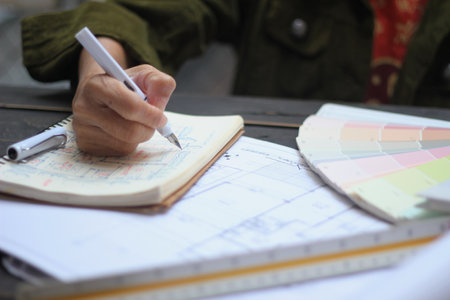 Hands of Asian female engineers are working on construction drawings on site.の写真素材