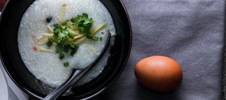 Chinese style porridge or porridge and fried dough stick or fried dough stick or donut or fried bread placed on a brown wooden table. Thai street food called "Porridge" and "Patongko", and toastの写真素材