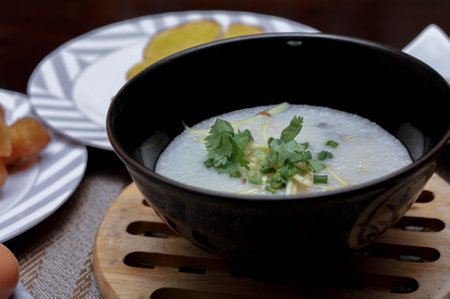 Chinese style porridge or porridge and fried dough stick or fried dough stick or donut or fried bread placed on a brown wooden table. Thai street food called "Porridge" and "Patongko", and toastの写真素材