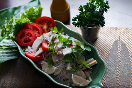 Spicy vietnamese sausages salad placed in a leaf-shaped green plate. With onion, garlic, red pepper...