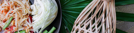 Thai papaya salad or " Somtum " in Thai. The famous local Thai street food dish with the taste of hot and spicy on wood table. Street food in Thailand.の写真素材