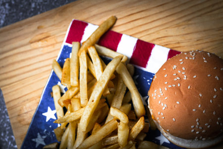 Cheese burger - American cheese burger with Golden French fries on wooden boardの写真素材