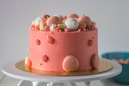 Tasty pink cake with macarons