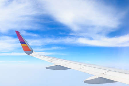 View from airplane window with blue sky and white cloudsの写真素材