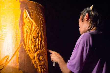 UBONTACHATANI,THAILAND-13 JULY :   Unidentified Man carving the big candle   for show in candle festival on July 13 at Ubonratchatani Thailandのeditorial素材