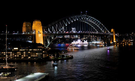 Night view of Sydney harbor bridge and North Sydney, boats sailing in the bay and Parramatta River. Focus on Bridge.の写真素材