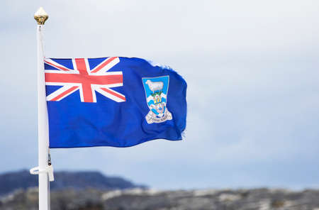 Wind blown tattered Falkland Islands flag with a cloudy sky. Some Motion Blurの写真素材