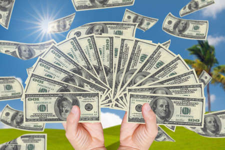 hand holding stack of 100 dollars