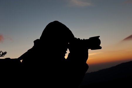 Silhouette of a cameraman against a sunriseの写真素材