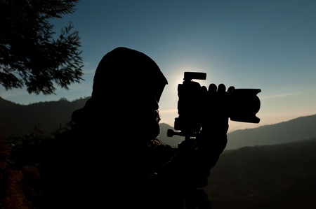Silhouette of a cameraman against a sunrise