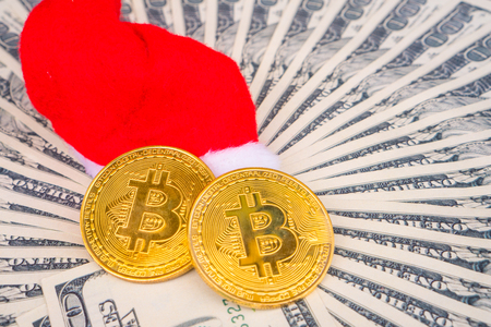 Medallion Bitcoin Gold on one hundred dollars banknote And Santa Claus Red Hat . Exchange bitcoin cash for a dollar. Digital money/Money of the future worldの写真素材