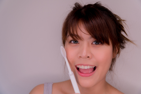 Beautiful girl holding a toothpaste. She has a crush. And good health. Her teeth look very white and beautiful.の写真素材