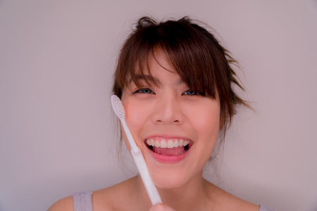 Beautiful girl holding a toothpaste. She has a crush. And good health. Her teeth look very white and beautiful.の写真素材