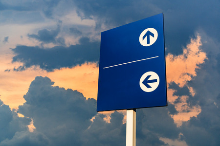 Traffic Signs: A blue routing label with space for text input. On the background of the dark sky in the sunset time. Copy space.の写真素材