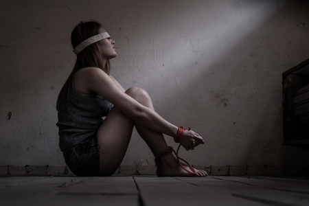 Victims of abducted women get wrists and feet in red. You have no way to fight or resist. She needs help. Hostage concept or female kidnapped from robber. Copy space. Dark Concepcion.の写真素材