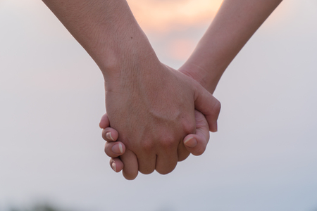 Woman and man holding hands, Happy couple holding hand in hand love in the parks, Expressing love. concept couple lover valentine day.の写真素材