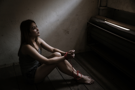 Victims of abducted women get wrists and feet in red. You have no way to fight or resist. She needs help. Hostage concept or female kidnapped from robber. Copy space. Dark Concepcion.の写真素材