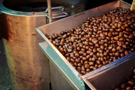 Hot chestnuts in a pan.  Chestnuts for sale in the market and festival. selective focus.の写真素材