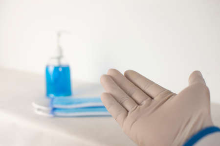 The doctor extended his hand to ask for something, with medical masks and alcohol sanitizer blurred...