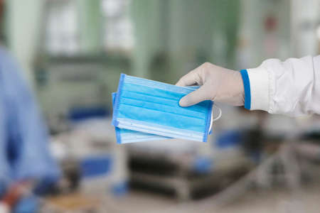 Medical masks in the hands of doctors are used for protection against germs and air pollution,...
