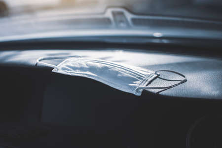 Surgical mask placed on car console in a carの写真素材