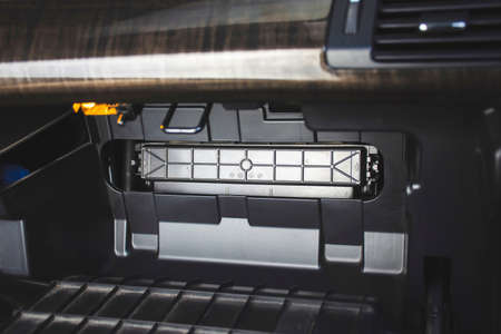 Car air conditioner filter slot with lid in the back of the document storage compartment in the car