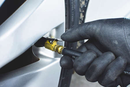The mechanic's hand was inflating the tires