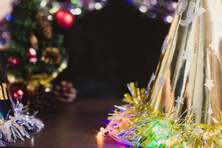 Merry christmas and happy new year concept decorated with christmas gold hat and christmas tree blurred background , copy spaceの写真素材