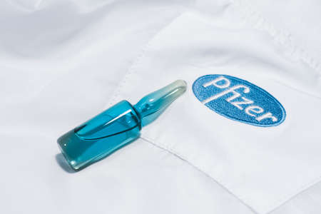 Rayong,Thailand - Jan 23, 2021 Blue medicine ampoule bottle  and Pfizer Biontech logo on white shirtのeditorial素材
